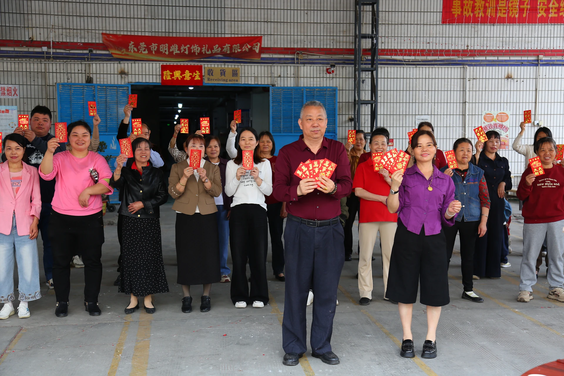 Mingxiong employees gathered at the factory entrance holding red envelopes for the return-to-work celebration